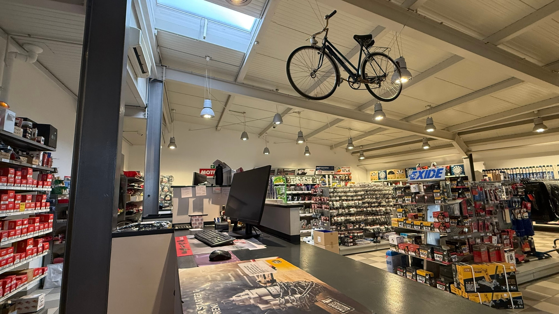 Verkaufsraum mit Theke, Fahrrad an der Decke und Blick in die Regale